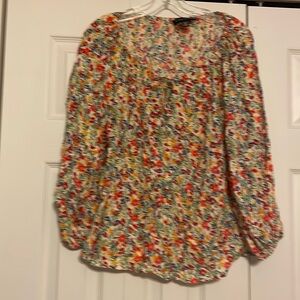 Premise floral blouse with a tie at the neck and cinched sleeves.